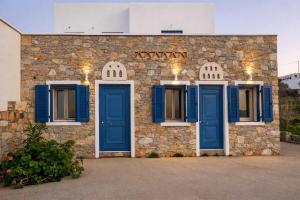 a stone building with blue shutters and windows at Dreamy View in Folegandros in Áno Meriá
