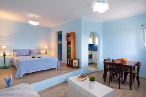 a blue bedroom with a bed and a table at Dreamy View in Folegandros in Áno Meriá +15 photos