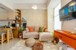 a living room with a couch and a flat screen tv at Condo in Cubao, Sunset & City Lights Chasing in Manila