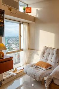 a room with a couch and a large window at Condo in Cubao, Sunset & City Lights Chasing in Manila +6 photos