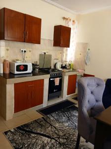 a kitchen with a stove and a microwave at Rose homes in Mombasa