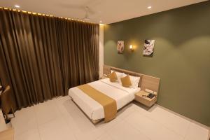 a bedroom with a bed and a large window at Hotel Pune Pride, Baner in Pune +108 photos
