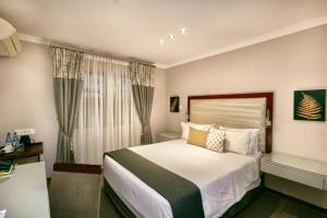 a hotel room with a bed and a window at Golden Crystal Hotel Gaborone in Gaborone