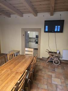 a dining room with a wooden table and a tv on the wall at Pod modříny in Adršpach