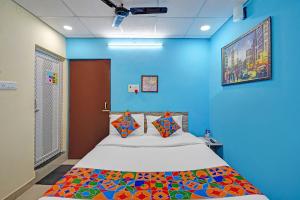 a bedroom with a bed in a blue wall at FabHotel The Radium Inn in Rānchī