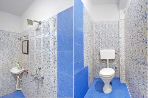 a blue tiled bathroom with a toilet and a sink at FabHotel The Radium Inn in Rānchī +22 photos