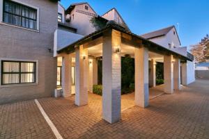 a building with columns on a brick parking lot at Golden Crystal Hotel Gaborone in Gaborone