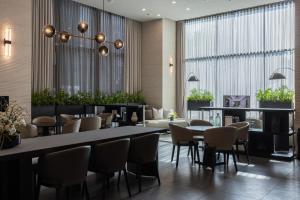 ein Restaurant mit Tischen und Stühlen in einer Lobby in der Unterkunft Anook Signature Hotel Incheon Guwol in Incheon