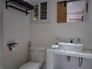 a white bathroom with a toilet and a sink at Sunset Garden in San Vicente +9 photos