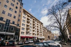 a street with cars parked in front of a building at Super Central Modern Flat with Balcony & View! #55''Smart TV #Fast Wi-Fi #Metro in Warsaw