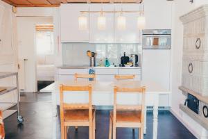 a kitchen with a white table and chairs at Surfers Sunset Spa with Jacuzzi & Panoramic Terrace in Grindelwald