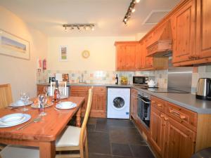a kitchen with wooden cabinets and a wooden table at 2 Bed in Newton Abbot oc-61775 in Ipplepen