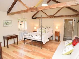a bedroom with a bed in a room with wooden floors at 1 Bed in Stoke Abbott oc-50885 in Stoke Abbott