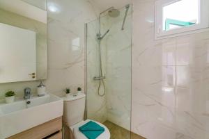 a bathroom with a shower and a toilet and a sink at Villa Sunshine Lanzarote by Villa Plus in Teguise +16 photos