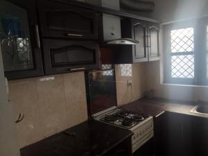 a kitchen with black cabinets and a stove top oven at Shiva House in Dehradun