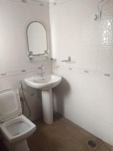a bathroom with a sink and a toilet and a mirror at Shiva House in Dehradun