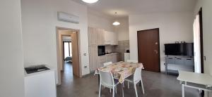 a kitchen and dining room with a table and chairs at il PORTICO in Tertenìa