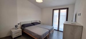 a bedroom with a bed and a large window at il PORTICO in Tertenìa