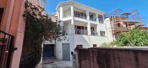 a white building with a balcony on the side of it at il PORTICO in Tertenìa