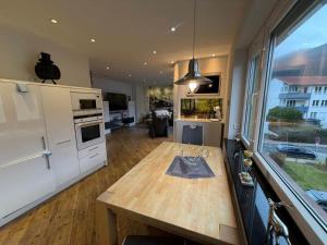 a kitchen with a wooden table and a large window at Ferienwohnung Harzoase in Bad Harzburg