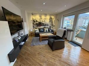 a living room with a couch and a tv at Ferienwohnung Harzoase in Bad Harzburg +15 photos