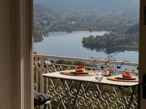 a table on a balcony with a view of a lake at Casa Lagò Lagò Panoramic Apartment in Ranzanico