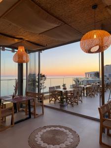 a patio with tables and chairs and a view of the ocean at Sky rooftop luxury suites in Durrës
