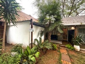 ein Haus mit einer Palme davor in der Unterkunft Lemon Cottage in Bela-Bela