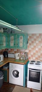 a kitchen with a stove and a washing machine at ABC Bladnoch in Newton Stewart