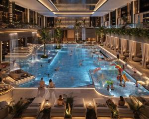 a large swimming pool in a building with people in it at Amiron Hotel in Dushanbe