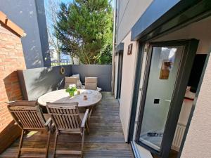 a patio with a table and chairs on a balcony at Lachmöwe by DeJu -4 Sterne DTV-Klassifizierung- in Norderney