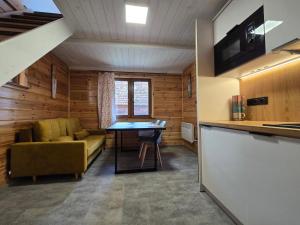 a living room with a couch and a table at Dolina Biebrzy - Chata Flisaka in Wroceń