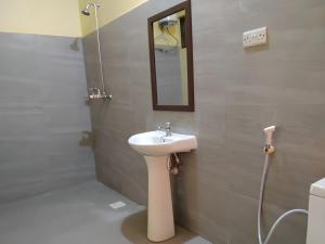 a bathroom with a sink and a mirror on the wall at Transit Motel Ukonga in Dar es Salaam