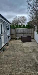 a backyard with a fence and a tv in it at Neptune Nights in Pontnewynydd