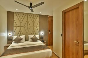 a bedroom with a bed and a ceiling fan at Hotel Emersion Residency in Pune