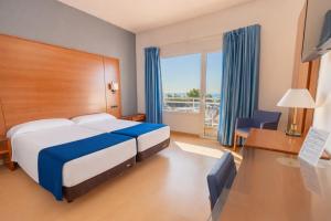 a hotel room with a bed and a desk and a window at Hotel Sant Jordi in Tarragona