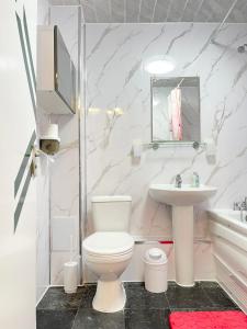 a white bathroom with a toilet and a sink at Makepe Bungalow Style in Douala +8 photos