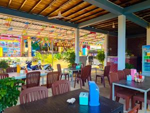 an empty restaurant with tables and chairs and a playground at New Land Hostel in Kaôh Rŭng (3)