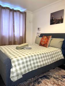 a bedroom with a bed with a checkered blanket at Makepe Bungalow Style in Douala