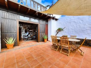 a patio with a table and chairs and a building at Casa Morro Herreno in Las Breñas