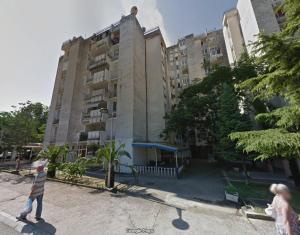 a man walking in front of a tall building at The Urban Oasis in Bar
