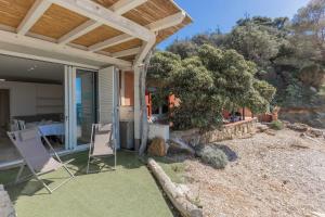 a patio with two chairs and a table on a house at Casetta sulla Spiaggia - HelloElba in Capoliveri