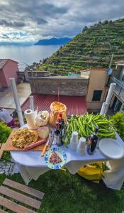 a table with food and vegetables on top of a hill at Sunset Manarola in Manarola