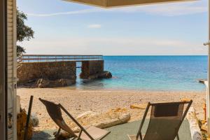a couple of chairs sitting on a beach at Casetta sulla Spiaggia - HelloElba in Capoliveri