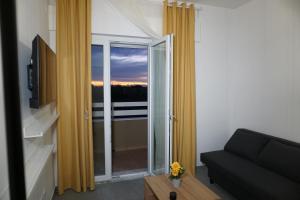 a living room with a couch and a large window at Farina Apartments in San Nicola La Strada