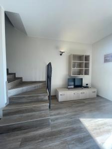 a living room with a staircase and a television at Villa Aurora Apartments in Sirmione