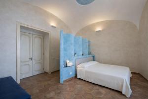 a bedroom with a white bed and a blue headboard at Hotiday Positano Volte Alte in Positano