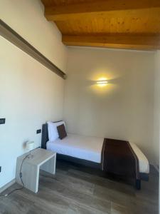 a small bedroom with a bed and a table at Villa Aurora Apartments in Sirmione