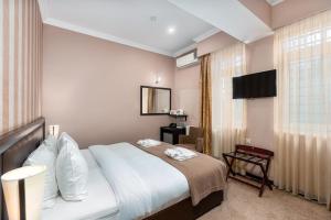 a bedroom with a large bed and a window at Kalasi Hotel in Tbilisi City