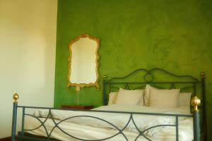 a green bedroom with a bed and a mirror at Casa Burnie in Monte Molino